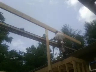 Carpenter setting a ridge beam over a new addition frame — Ice Dam Removal by Roofing Brothers in Perrysburg