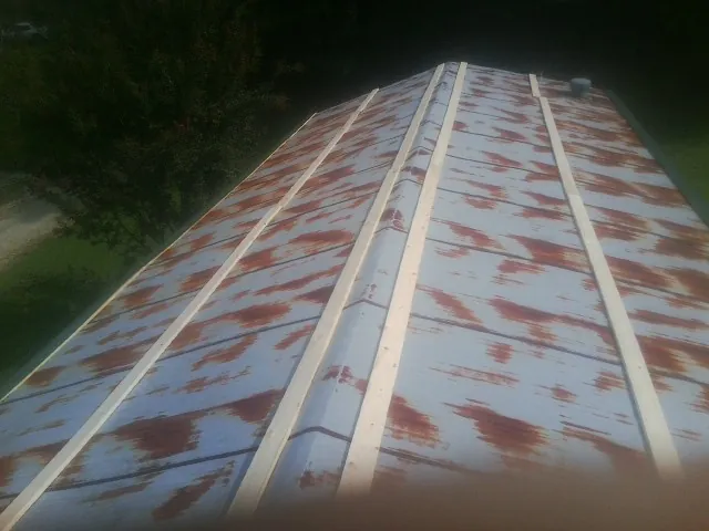 Rusted metal roof panels with new wood purlins before replacement — Storm Damage Roof Repair in Perrysburg by Roofing Brothers